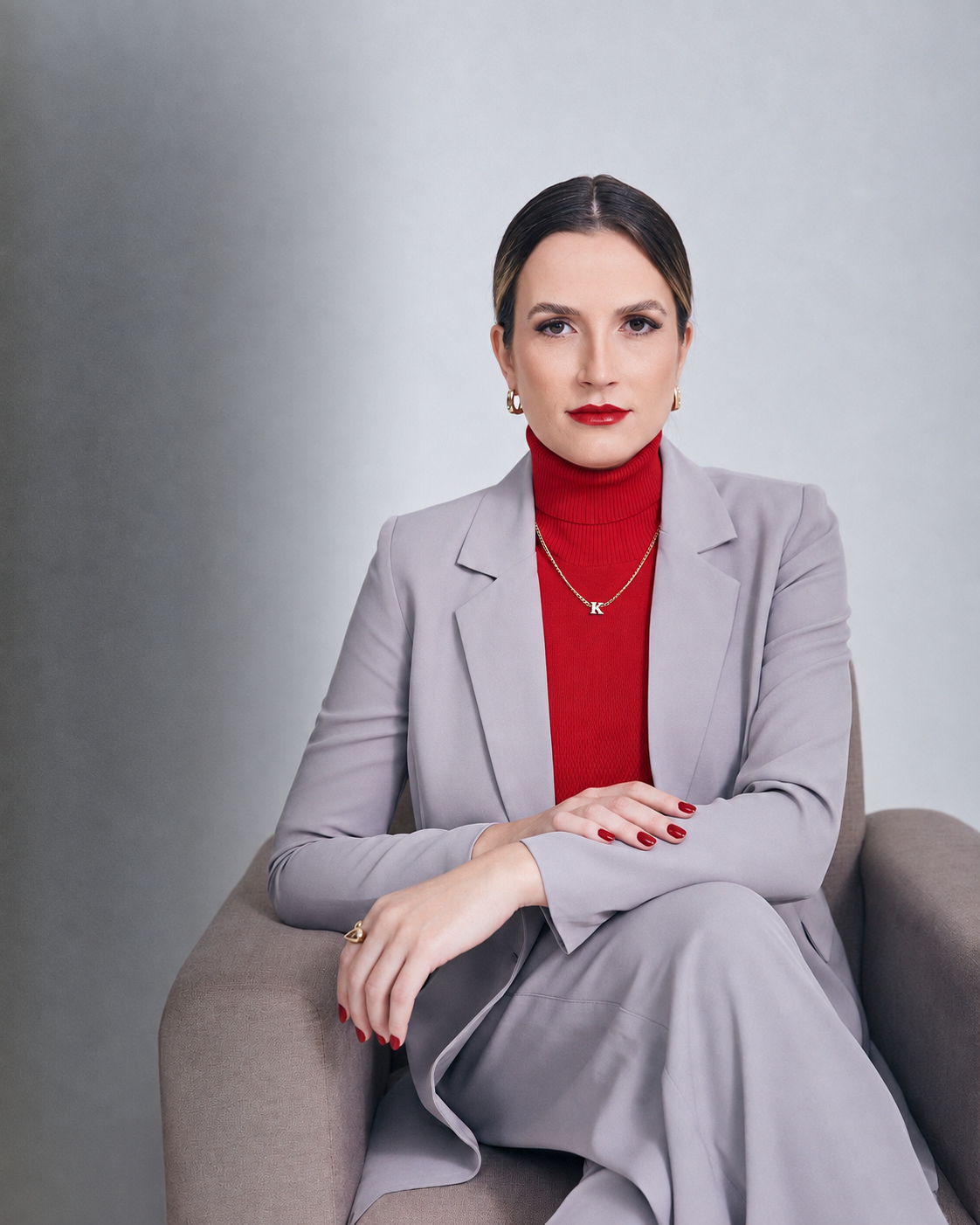 Retrato profissional da Dra. Karen Santini, de terno cinza e blusa vermelha, sem jaleco